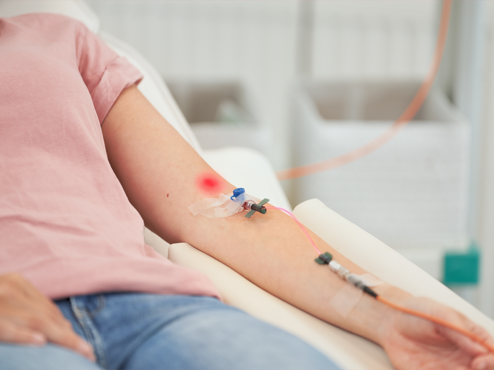 Photo of intravenous laser therapy, woman with a cannula in the crook of her elbow